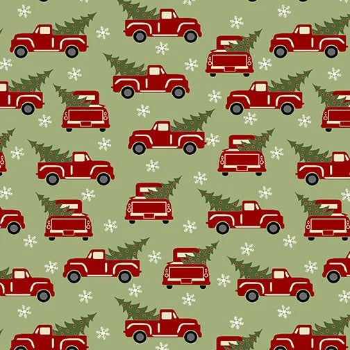 The Red Truck Holiday Green Flannel Fabric Yardage features red pickup trucks with Christmas trees and scattered white snowflakes on a festive green background.