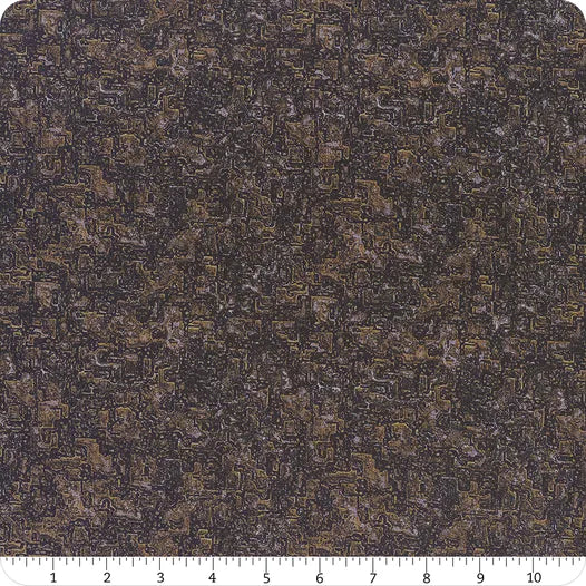 A close-up shows Steampunk Menagerie Rust Metal Fabric Yardage by In the Beginning Fabrics, featuring a dark brown and black abstract, maze-like pattern. A white ruler at the bottom edge is marked in inches from 1 to 8 for scale.