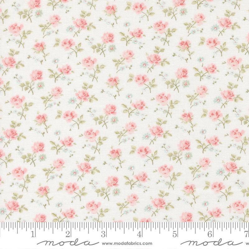 The Abide Linen White Sprigs Fabric Yardage by United Notions features small pink roses and green leaves on white, shown with a ruler in inches—ideal as a charming blender print for quilts and crafts.