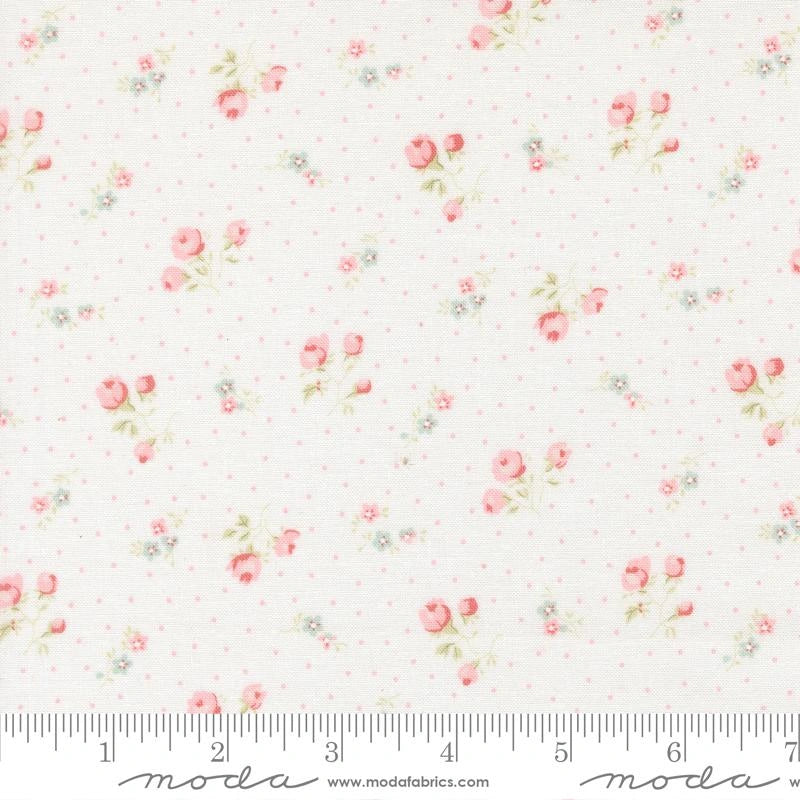 Abide Linen White Small Floral Fabric Yardage by United Notions features subtle pink polka dots, clusters of pink roses, and tiny blue flowers. Ruler in image shows inch marks from 1 to 8, ideal for quilting projects.