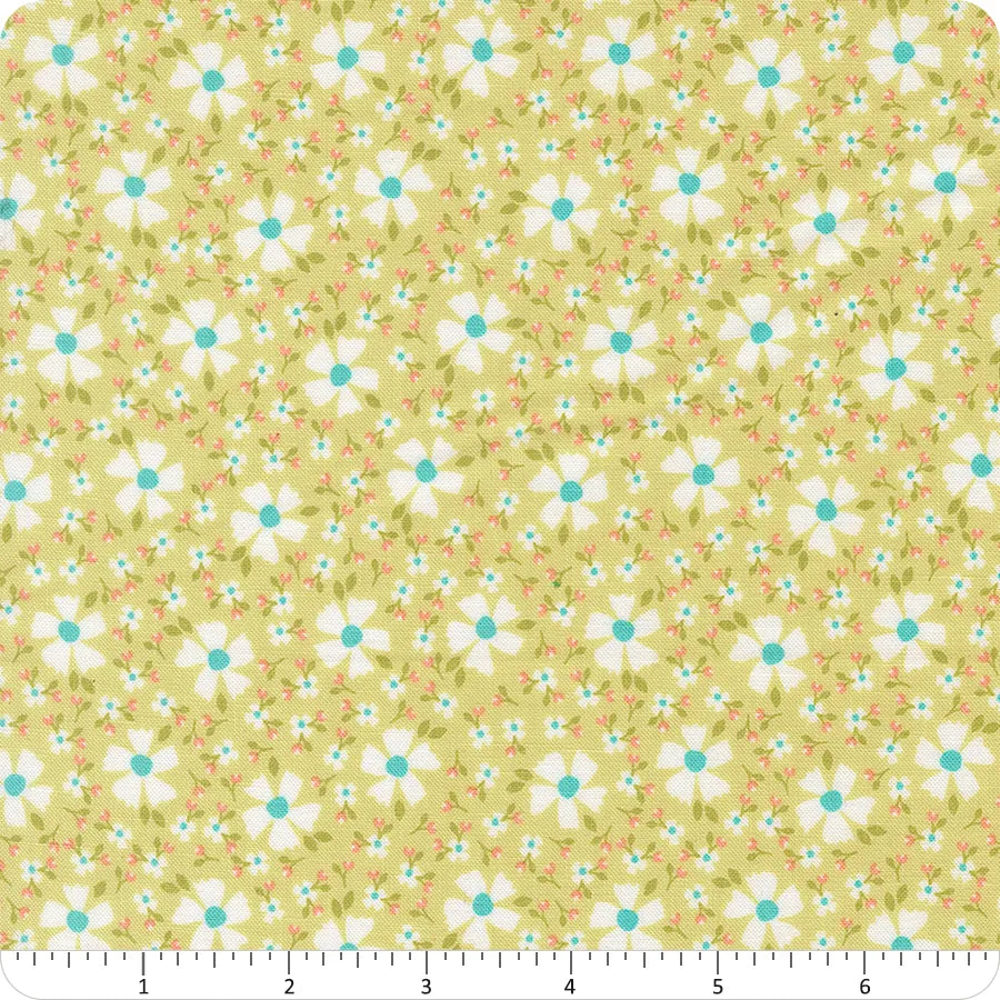 In the Garden Lime Blossom Florals Fabric Yardage by United Notions showcases yellow fabric with a repeating floral pattern of white flowers with blue centers plus small red and blue flowers, shown beside a ruler in inches for scale.