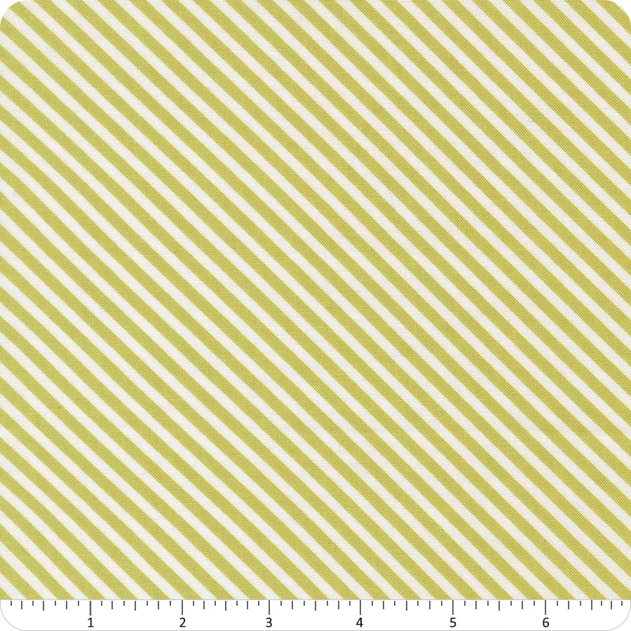 The In the Garden Pistachio Bias Stripe Fabric Yardage by United Notions features evenly spaced yellow and white diagonal stripes with a ruler at the bottom measuring 0–7 inches, making it ideal for quilt fabric projects.