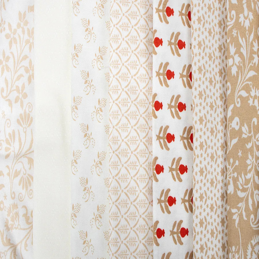 The Buon Natale Fat Quarter Bundle features seven Fig Tree & Co fabric strips with beige and white floral, geometric, and leaf motifs; one strip includes red flower accents—ideal for Christmas quilting projects.