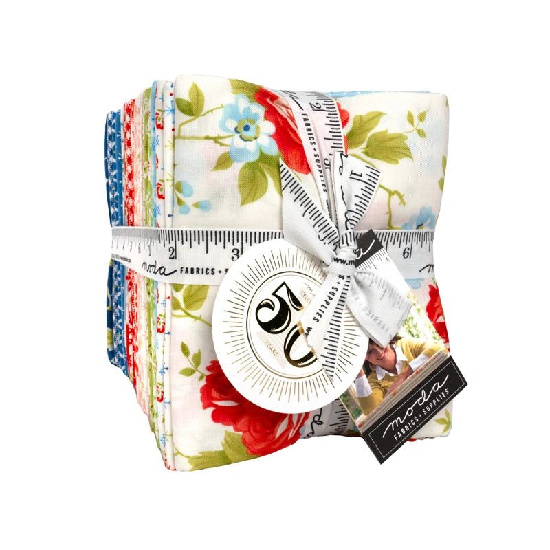 Bright, vintage floral prints stack neatly in the Rosie Fat Quarter Bundle 37pc by United Notions, tied with a measuring tape ribbon and finished with a round tag and label for a charming presentation.