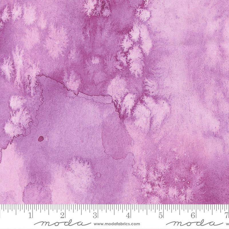 A close-up of Soulstice Flow Lavender Fabric Yardage by United Notions shows pink and purple watercolor-style cotton with abstract, cloud-like patterns. A ruler at the bottom marks 4 to 8 inches.