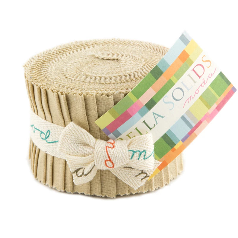 A rolled bundle of beige fabric strips tied with a ribbon, the Bella Solids Tan Junior Jelly Roll by United Notions features a colorful label for extra charm.