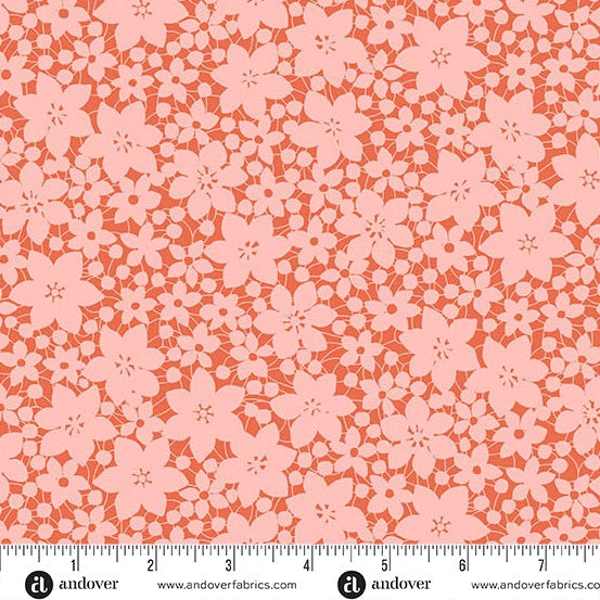 The Andover Color Me Whispered Salmon Laced Blooms Fabric features pink floral silhouettes densely arranged on a reddish-orange background. A ruler at the bottom shows inches, with the Andover logo below.