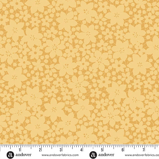 The Color Me Whispered Saffron Laced Blooms Fabric Yardage by Andover features a yellow floral pattern with overlapping flowers and leaves in subtle shades. The premium cotton fabric is shown with a ruler and the Andover logo at the bottom.