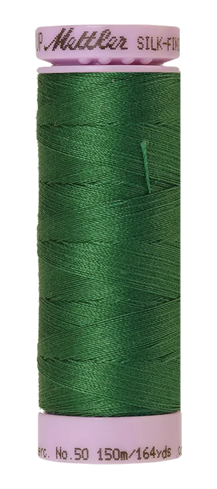 A spool of Mettler Cotton Silk Finish 50wt 150m Bright Green thread with white ends, featuring product name and thread details.