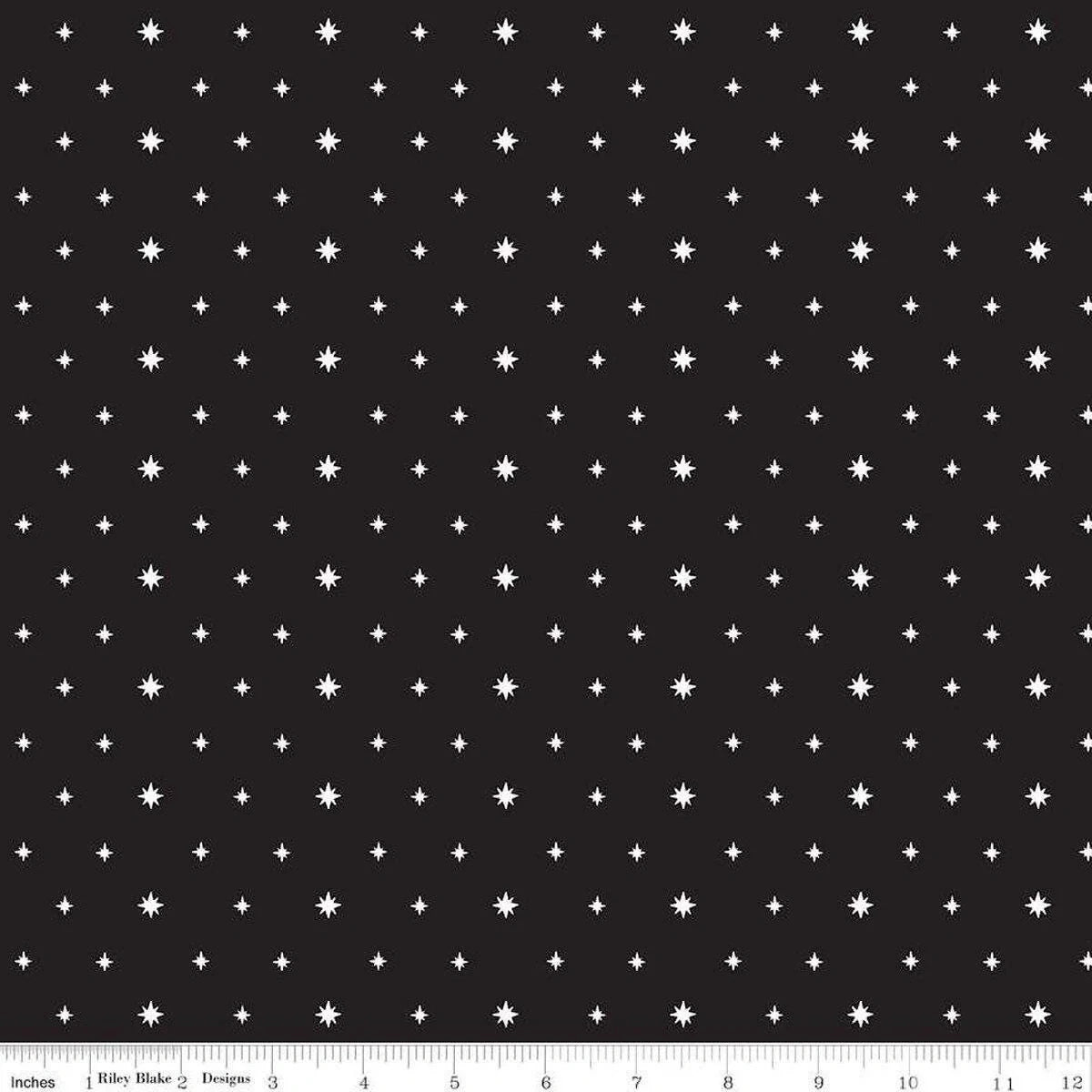 Charming Christmas Black Stars Fabric Yardage by Riley Blake features a black background with a repeating pattern of small white stars and dots, perfect for Christmas quilts. Ruler at the edge shows inches 0-12 for scale.