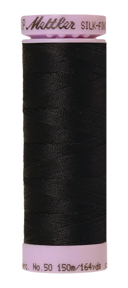 A spool of Mettler Cotton Silk Finish 50wt 150m Deep Well thread, featuring black cotton sewing thread with a light pink cap and base, ideal for quilting projects.