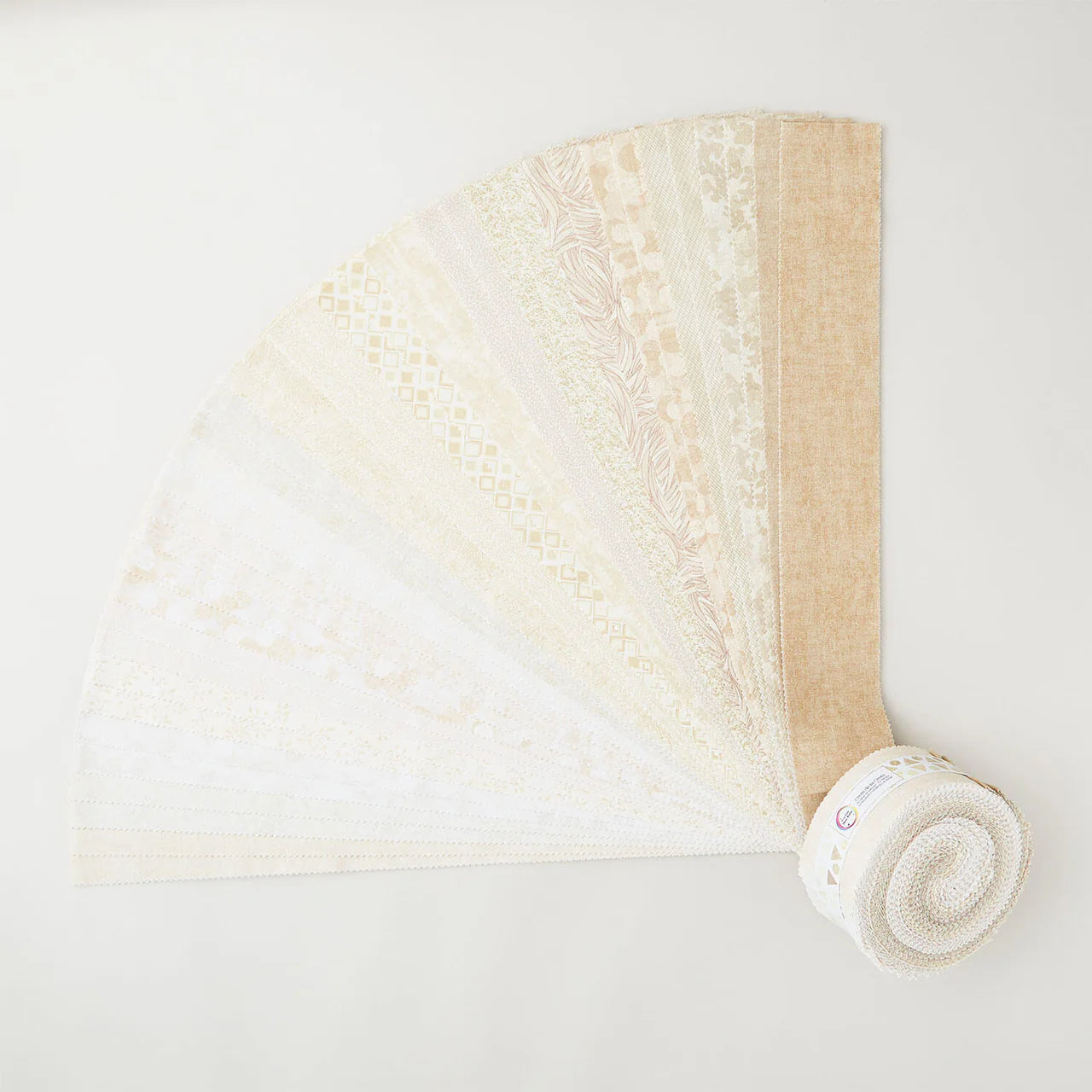 The I've Got Hue, Babe Crème de la crem 2.5in Strips from Jaftex - Henry Glass Fabrics are displayed in a fan shape, featuring neutral beige and white tones with subtle patterns and textures on each strip.