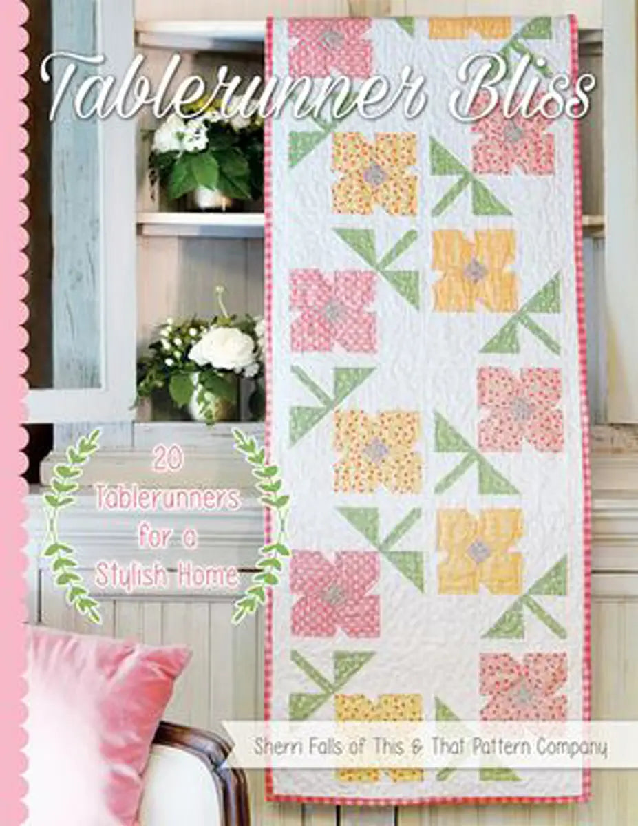 Tablerunner Bliss by Sherri Falls features a pastel book cover with a floral quilted tablerunner in pink, yellow, and green on a white shelf with flowers. Includes 20 tablerunners for stylish table decor.