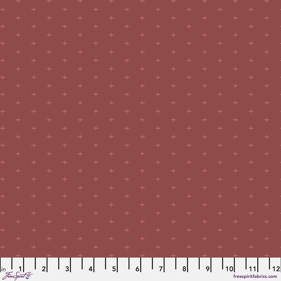 Chromatics Brick Cross Stitch Fabric Yardage by Jaftex - FreeSpirit is a reddish-brown cotton with small, evenly spaced plus signs. A white measuring tape runs along the bottom edge, marked from 0 to 12 inches.