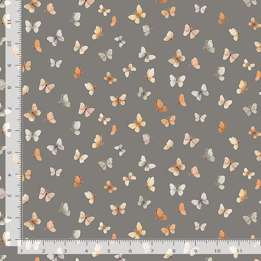 Count On Me Pewter Flutter Fabric Yardage by Dear Stella is a pewter gray quilting cotton with small orange, cream, and light brown butterflies scattered across it. A white ruler runs along the left and bottom edges for scale.