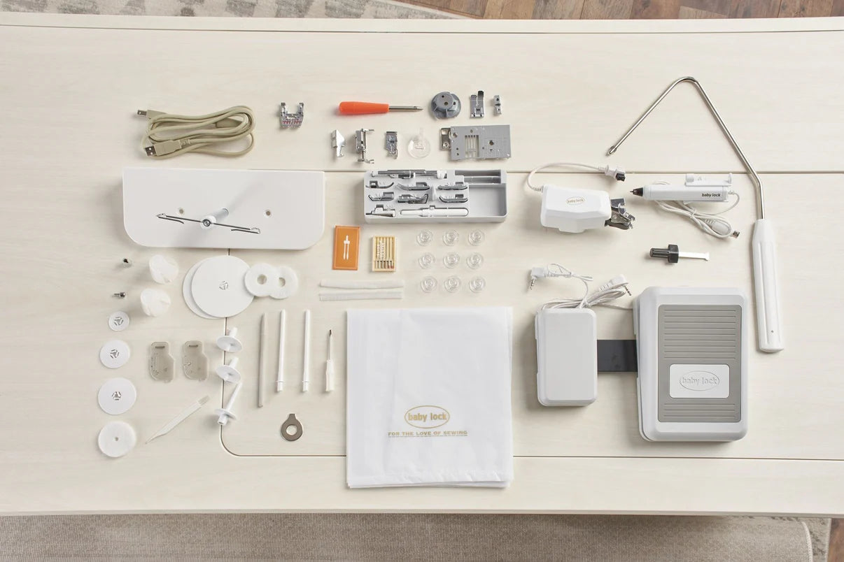 The Baby Lock Ballad Sewing and Quilting Machine kit, with 60 Days FREE Online Classes, includes cords, presser feet, bobbins, needles, a foot pedal, instruction manual, and various sewing & quilting accessories displayed on a light surface.