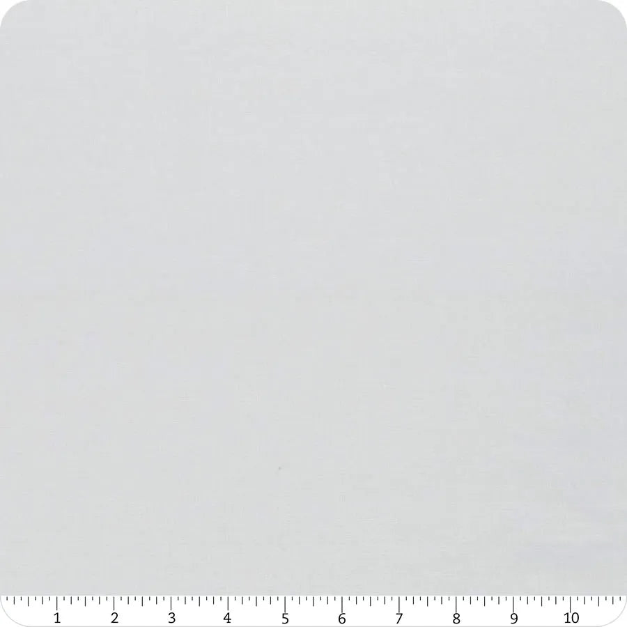 A close-up of United Notions’ Bella Solids Zen Gray Junior Jelly Roll fabric, with a ruler showing inches 1–12 along the bottom edge, highlights its scale and texture—ideal for quilting projects.