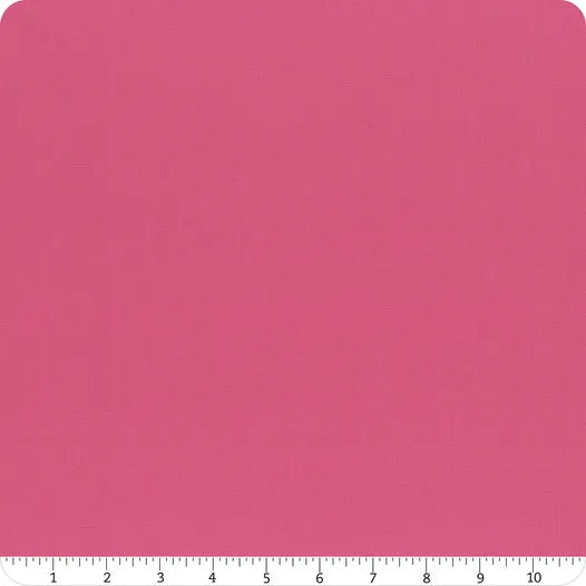 A square piece of Riley Blake's Confetti Cotton™ Passion Fabric Yardage is shown, with rounded top corners and a white ruler along the bottom edge marking 1 to 10 inches. This premium solid pink quilting cotton features a subtle texture.