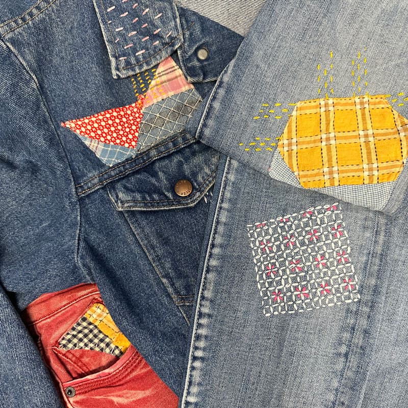 Learn hand-stitched embroidery and stylish fabric repair using Sashiko techniques in our Sashiko Basics Class—perfect for adding colorful patches and unique patterns like yellow plaid or red-and-blue checks to your denim jackets and jeans.