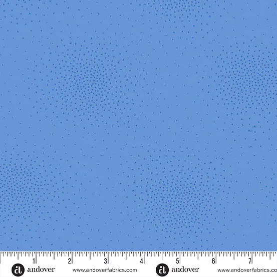 Spritz Bluebonnet Fabric Yardage by Andover features a blue fabric with subtle small dots in circular clusters. A ruler at the bottom shows inches, and the Andover logo marks this quilting fabric.
