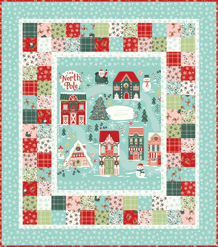 The North Pole Quilt Kit - FLANNEL by Quilted Joy features a festive central North Pole scene with snowy houses and sleigh, framed by colorful holiday patchwork borders in red, green, blue, and white.