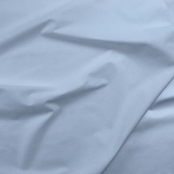 Painter's Palette Solids Monaco Fabric Yardage by Paintbrush Studio (PBS) features light blue quilting cotton with subtle wrinkles and gentle folds for a soft, smooth surface texture.