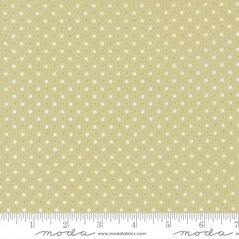 Abide Light Green Dots Fabric Yardage by United Notions features a light green cotton fabric with evenly spaced small white polka dots. A ruler at the bottom edge displays measurements in inches.