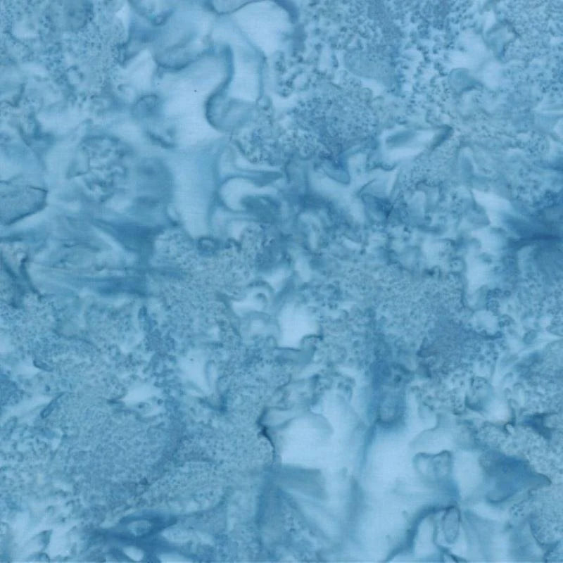 The 1895 Watercolors Ceylon Batik Fabric Yardage by Hoffman Fabrics features soft, abstract blue patterns with marbled, cloudy textures—ideal for quilting projects.