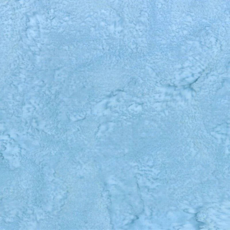 The light blue, cloudy marbled surface resembles brushed paint and evokes the soft, slightly uneven look of 1895 Watercolors Peace Batik Fabric Yardage by Hoffman Fabrics—perfect for quilt projects needing a gentle texture.