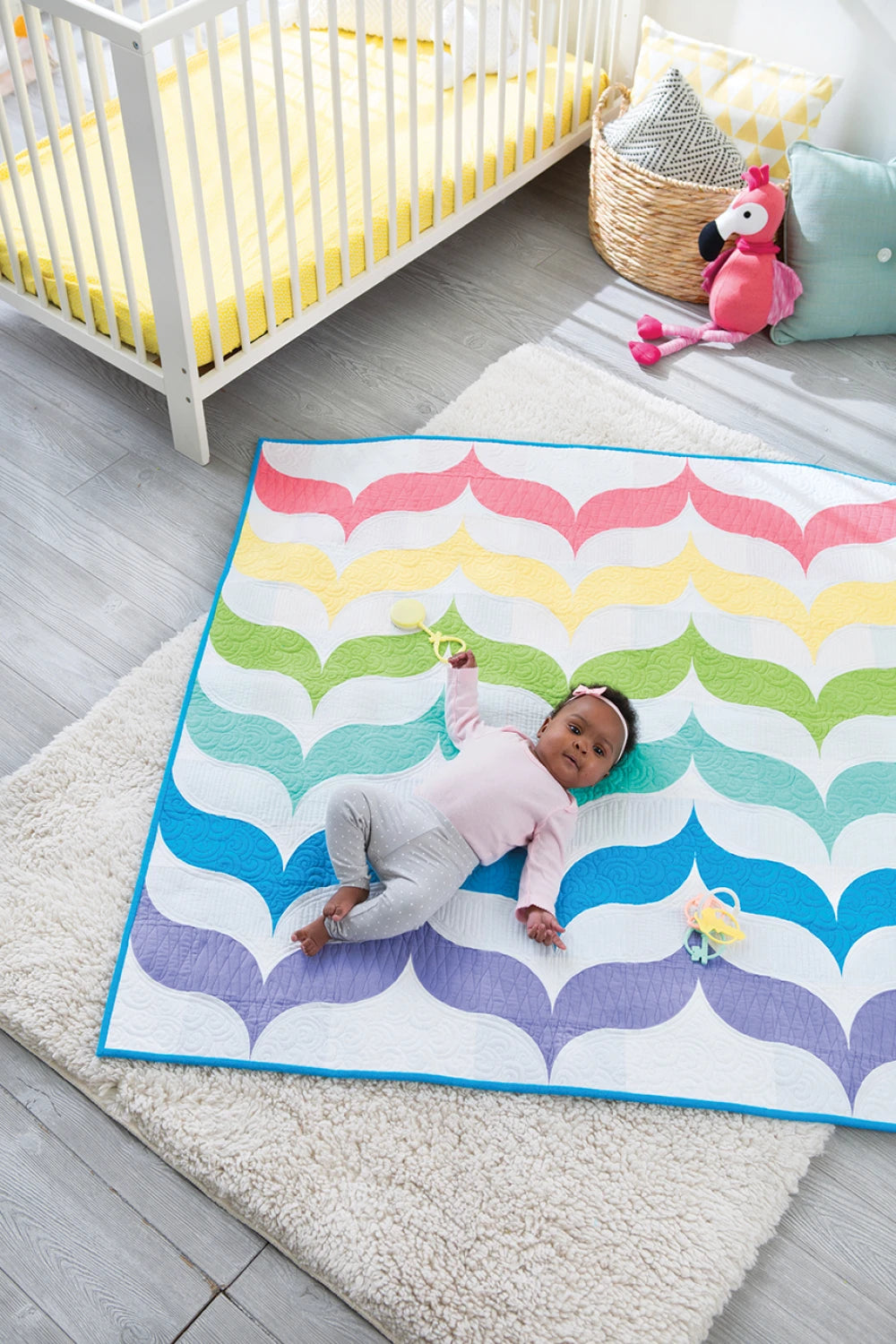 Bundle Up Baby Quilts sample quilt draped over crib