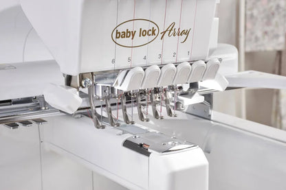 Close-up of the Baby Lock Array 6 Needle Embroidery Machine, displaying its six numbered needle positions with threads, metal needle bars, and part of the white machine body.