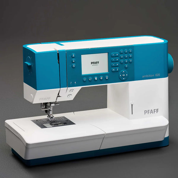 A pre-loved blue and white Quilted Joy Pfaff Ambition 620 computerized sewing machine sits on a dark surface, featuring an LCD screen, control buttons, and multiple stitch settings—ideal for quilting enthusiasts.