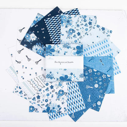 A circular display of Riley Blake’s Blue Blooms and Threads 5" Stacker features blue and white squares with floral, checkered, striped, and scissor prints. The label in the center highlights its charm pack for quilting precuts.