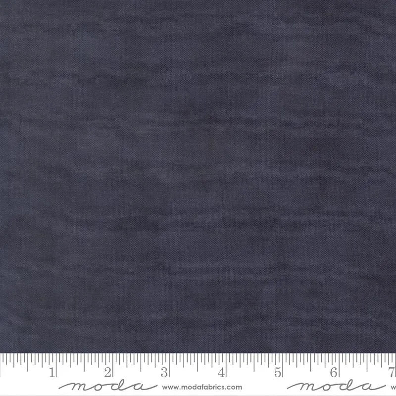A swatch of Loyalty Blue Shaded Solid fabric by United Notions from the America 250 Years collection, showing its dark gray mottled texture. A white ruler with inch marks and www.modafabrics.com is along the bottom edge.