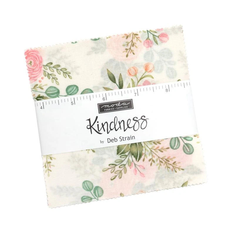 A 5" square fabric swatch with a pastel floral print, wrapped in a white "Kindness by Deb Strain" band with a ruler graphic—ideal for quilting—as the Kindness 5" Charm Pack by United Notions.