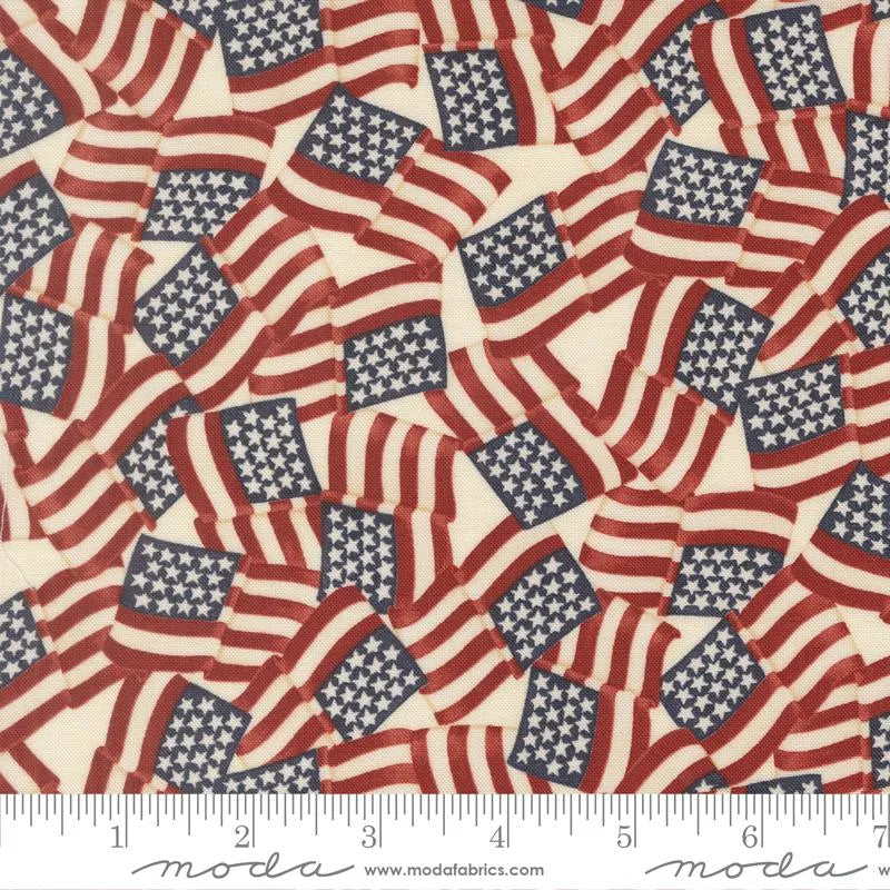 America 250 Years Parchment Waving Flags Fabric Yardage by United Notions showcases overlapping vintage-style American flags with red and white stripes and blue fields of stars, plus an inch ruler along the bottom for scale.