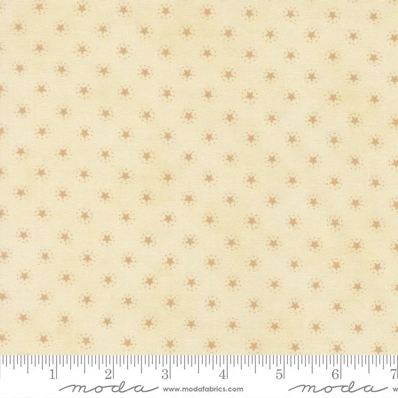 America 250 Years Parchment Tan Stars Fabric Yardage by United Notions features cream-colored fabric with a repeating pattern of small, light brown sunburst stars and includes a white ruler with black markings and logo for scale along the bottom.
