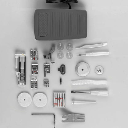 Quilted Joy's Pfaff Quilt Ambition 635 Sewing and Quilting Machine accessories—presser feet, bobbins, needles, spool caps, and more—are displayed neatly on a white surface.