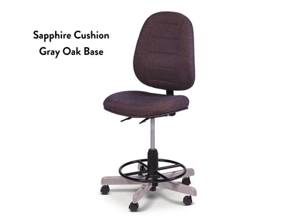 The Koala SewComfort Chair features a sapphire blue cushion, gray oak wheeled base, and circular footrest. Ergonomic and stylish, it’s perfect for sewing. Text beside the chair: Sapphire Cushion Gray Oak Base.