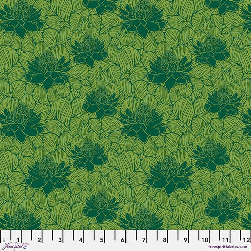 The Paradise Blooms Waratah Emerald Fabric Yardage by Jaftex - FreeSpirit features a green base with dark green lotus flowers and light green leaves. A white ruler along the bottom edge displays measurements in inches from 1 to 12.