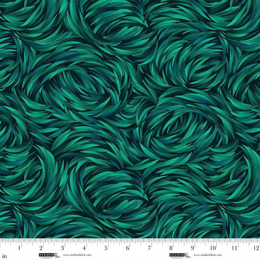 The QT Fabrics Tempest Jadite Swirl 108" Wide 3 Yard Quilt Fabric Back Pack features a seamless, textured green leaf pattern. A ruler at the bottom shows inches from 0 to 12 for scale.