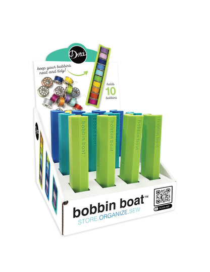 Checker Distributor’s Bobbin Boat display box features compact sewing organizers in blue, green, and teal. Each holds 10 bobbins for neat storage, with a front QR code on the packaging to highlight its use as a bobbin organizer.