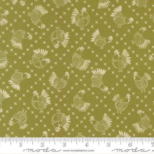 The Henhouse Cross Stitch Chickens Novelty Grass Fabric Yardage by United Notions features cream sketch-style chickens and cross-stitch X marks on olive green quilting cotton. A ruler at the bottom shows inch measurements.