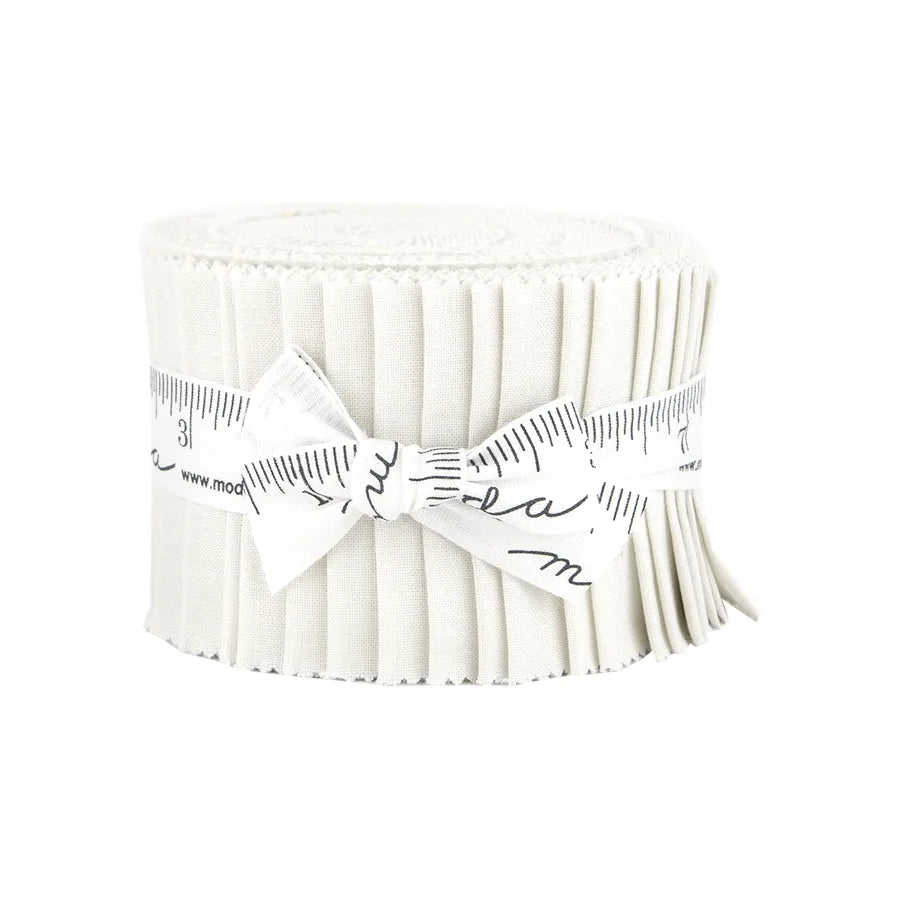 A rolled-up strip of pleated white United Notions fabric, secured with a measuring tape ribbon and tied in a bow, resembles the Bella Solids Feather Junior Jelly Roll.