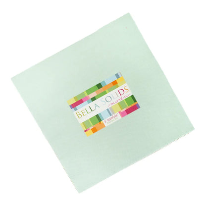 A pale blue 10" square fabric from the Bella Solids Home Town Sky Junior Layer Cake by United Notions, featuring a colorful center label with “Bella Solids Moda” and “Home Town Sky” written below.