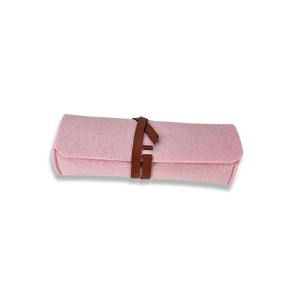 The Felt Pencil Notion Pouch D Rose is a soft pink felt pouch, rolled up and secured with a brown vegan leather closure, shown on a white background.