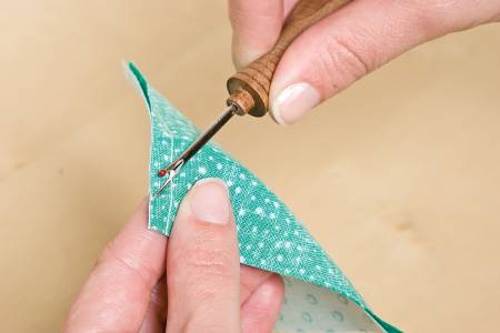 image of Alex Andersons 4-in-1 Essential Sewing Tool being used as a seam ripper