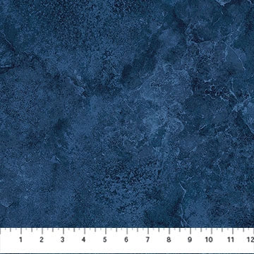 A Northcott Stonehenge Navy Quartz Flannel 108" Wide 3 Yard Quilt Fabric Back Pack swatch in mottled dark blue, with a white ruler along the bottom edge showing inches from 1 to 12.