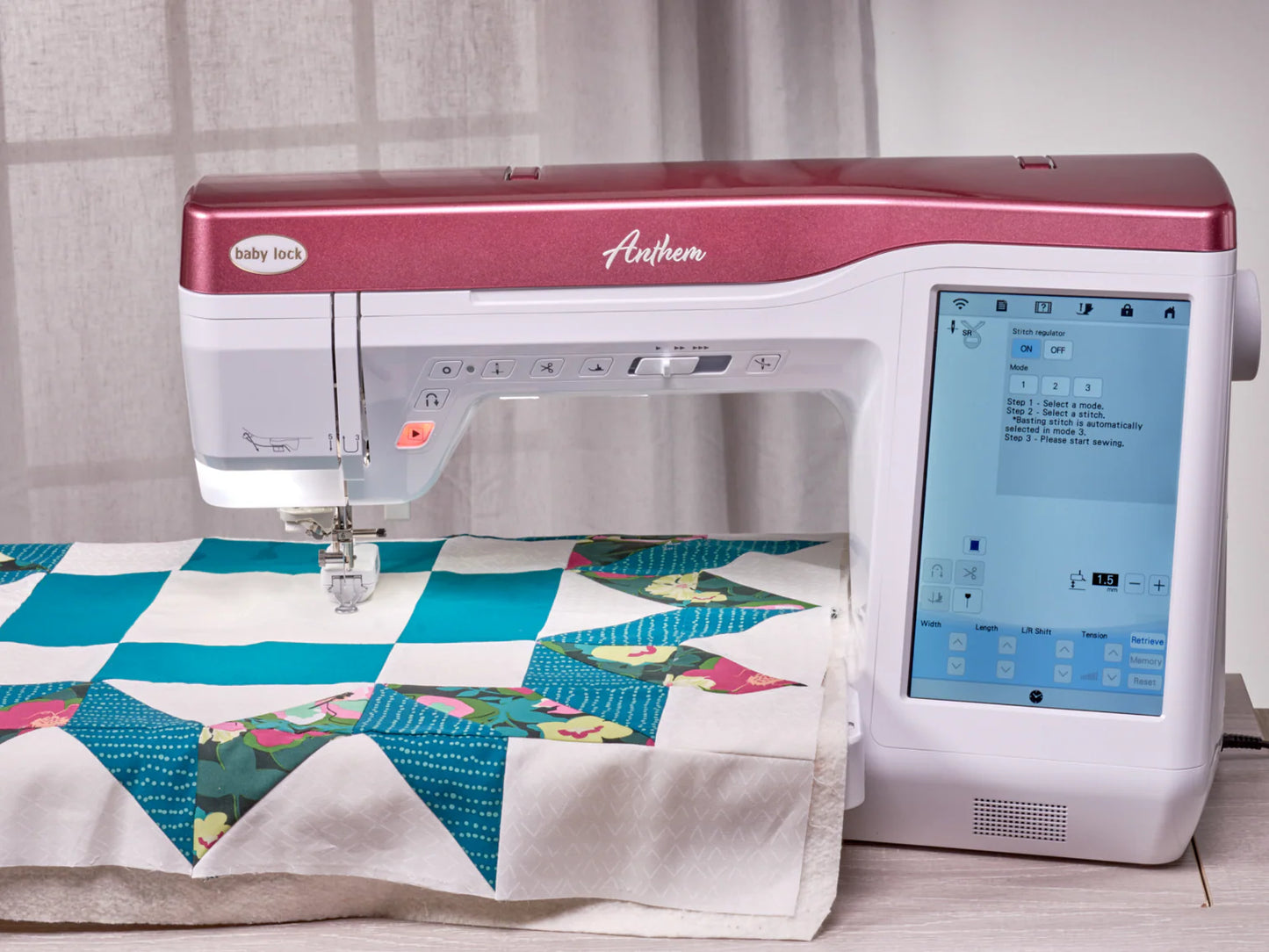 A pink and white Baby Lock Anthem Sewing & Quilting Machine with FREE 60 Days of Online Classes is quilting a colorful blanket featuring a teal star, while its touchscreen displays digital sewing options.
