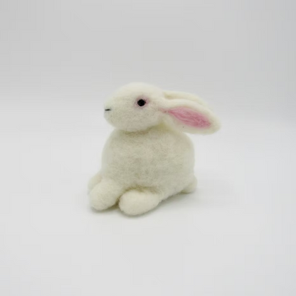 The Feather Felts Bunny - Needle Felting Kit No Foam features a small, plush white rabbit with pink ears, ideal for bunny needle felting projects. The rabbit sits on a plain white background, facing slightly left with a soft, fluffy texture.